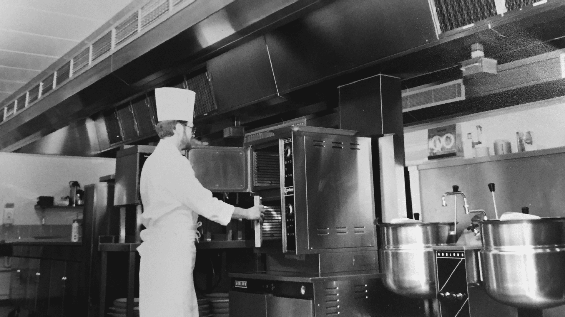 a historic photo of a person using a machine